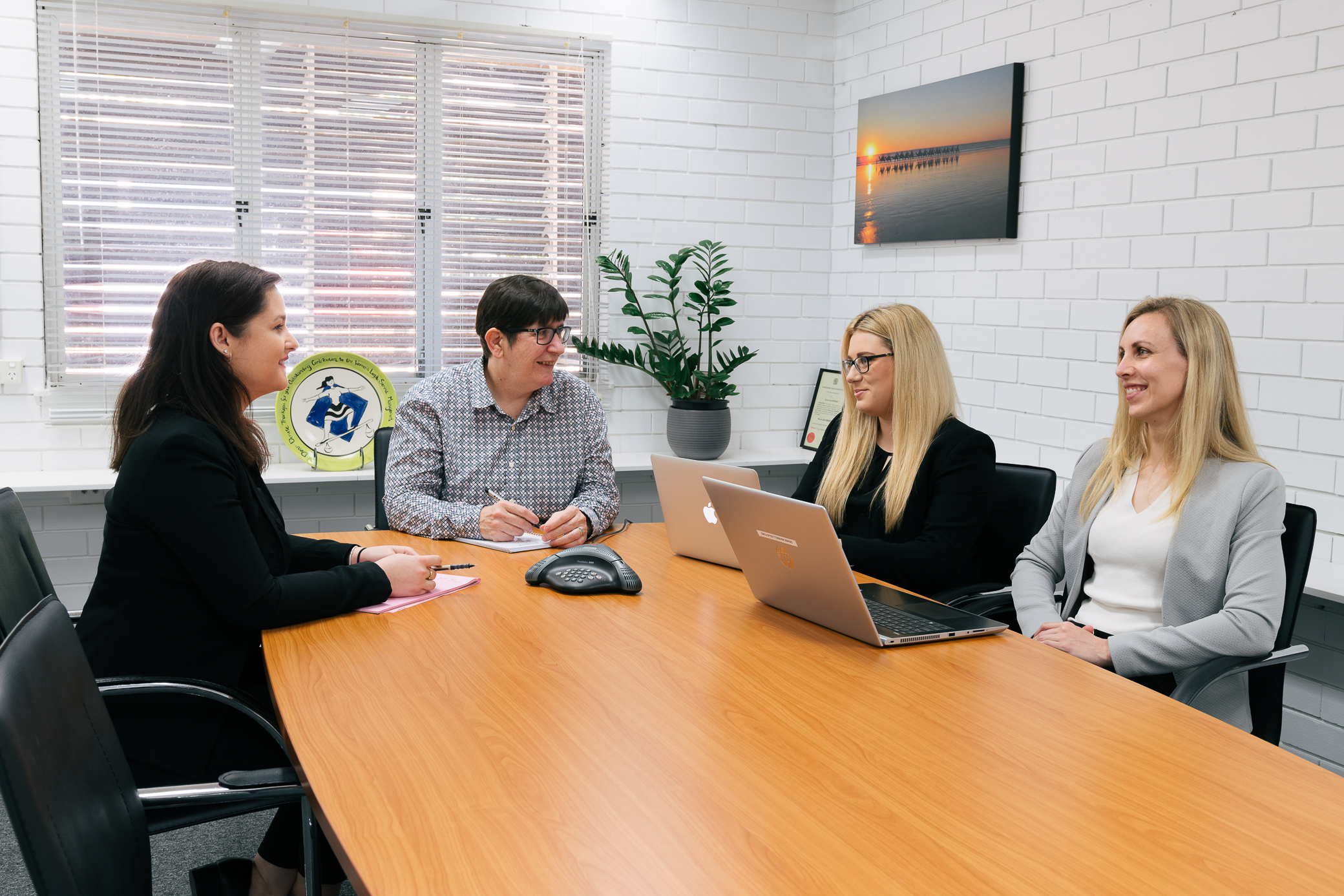Denise Maxwell Solicitors team working at table in Brisbane office
